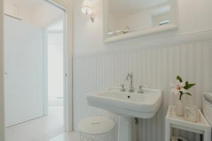 uma casa de banho branca com um lavatório e um WC em The sailor's wife house - Santa Croce em Santa Croce Mare