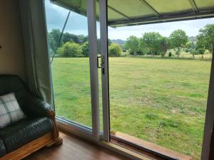 um quarto com uma janela com vista para um campo em Courtlands farm camping and glamping em Canterbury