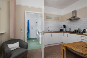 a kitchen with a couch and a chair in a room at Epchris House in Ilfracombe