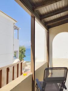 a chair on a balcony with a view of the ocean at Mairi's SummerHouse - seaside, en-suite, 2-bedroom summerhouse in Souvala