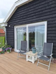 two chairs and a table on a wooden deck at Gastenhuis Amstelmeerzicht. in Westerland +8 photos