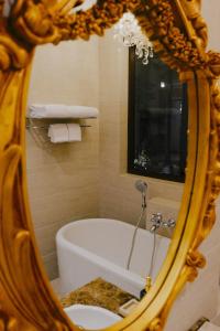 a mirror in a bathroom with a bath tub at Dandaman villa in Yogyakarta