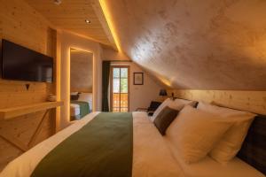 um quarto com uma cama grande e uma televisão em PRIVILLAGE Stare - B&B em Bohinj