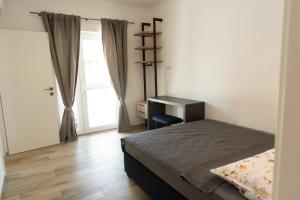 a bedroom with a bed and a desk and a window at Neue VILLA ROSE Fazana in Pula