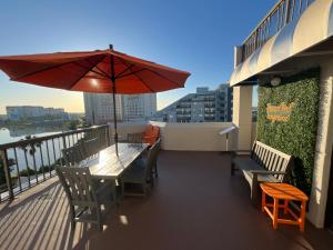 a table and chairs on a balcony with an umbrella at Rooftop Terrace 2 Bedroom Tangerine Suite - Perfect View, Central Location in Orlando