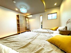 a large bedroom with two beds and a window at 螢居- 3層100坪別墅 心齋橋道頓堀2站 in Osaka