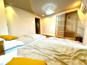 a bedroom with two large beds in a room at 螢居- 3層100坪別墅 心齋橋道頓堀2站 in Osaka