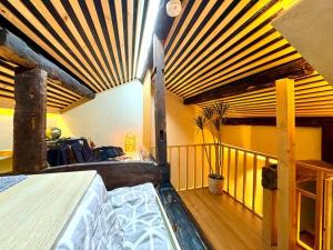a bedroom with a bed and a balcony with wooden ceilings at 螢居- 3層100坪別墅 心齋橋道頓堀2站 in Osaka