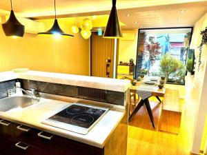 a kitchen with a sink and a stove top oven at 螢居- 3層100坪別墅 心齋橋道頓堀2站 in Osaka