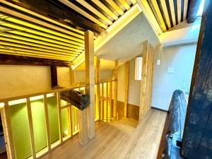 a room with wooden floors and a room with a ceiling at 螢居- 3層100坪別墅 心齋橋道頓堀2站 in Osaka