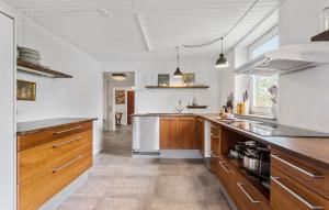 een keuken met witte muren en houten kasten bij 5 Bedroom Beach Front Home In Hesselager in Hesselager