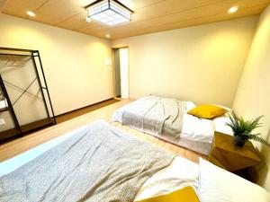 two beds in a large room with a mirror at 螢居- 3層100坪別墅 心齋橋道頓堀2站 in Osaka
