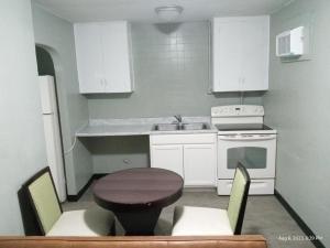 una pequeña cocina con mesa y fregadero en Homes -N - Courts en Sanford