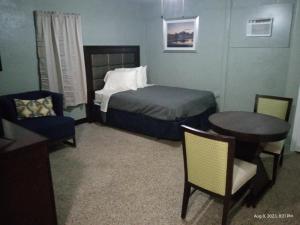 1 dormitorio con 1 cama, mesa y sillas en Homes -N - Courts en Sanford