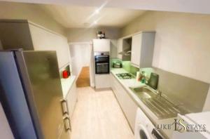a small kitchen with a refrigerator and a sink at Luke Stays - Welbeck Road in Old Walker