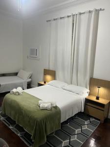 1 dormitorio con 1 cama grande y 2 mesitas de noche en Casa Aconchegante-Rio de janeiro, en Río de Janeiro