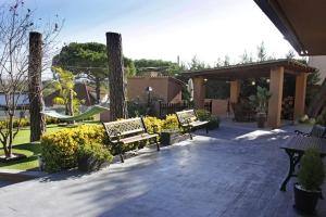a patio with benches and bushes and a pavilion at Villadora in Santa Coloma de Farners