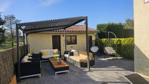 a pergola with couches and a table on a patio at Villadora Piscina privada & jacuzzi Cerca de la costa brava in Santa Coloma de Farners