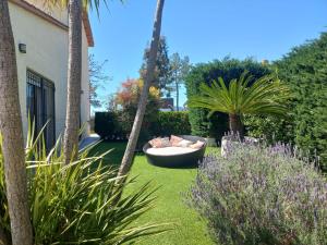 a garden with a couch and palm trees and plants at Villadora Piscina privada & jacuzzi Cerca de la costa brava in Santa Coloma de Farners