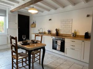 a kitchen with a table and a table and chairs at Charming converted Granary in Capelle-lès Hesdin