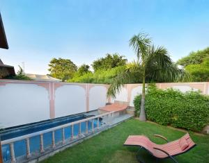 a backyard with a swimming pool and two chairs at Buena Vista Luxury Garden Spa Resort in Jaipur