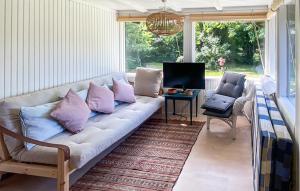 - un canapé dans le salon avec des oreillers violets dans l'établissement Gorgeous Home In Tisvildeleje With Wifi, à Tisvildeleje