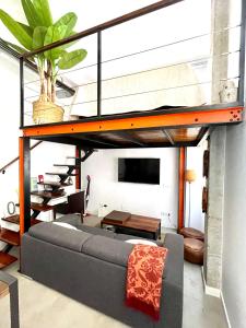 Una cama alta en una sala de estar con un sofá. en Estudio céntrico junto Wanda, Ifema y aeropuerto, en Madrid