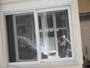 een persoon die een foto neemt in een venster bij Penelope's and John's House in Kavala