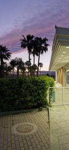 a building with palm trees in front of a building at Partenone Resort Hotel in Riace Marina