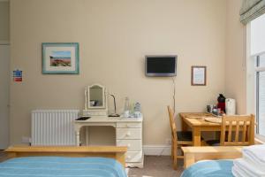 a bedroom with a desk and a table with a mirror at Epchris House in Ilfracombe