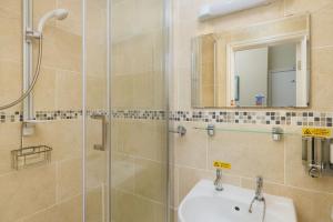 a bathroom with a shower and a sink and a mirror at Epchris House in Ilfracombe