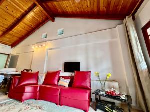 a red couch in a living room with red pillows at Στούντιο Κέντρου Άνω πόλης Πάτρας in Patra