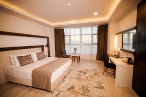 KaramanにあるGrand Hotel & Convention Center Karamanのベッドとデスクが備わるホテルルームです。