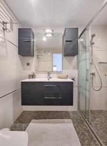 La salle de bains est pourvue d'un lavabo et d'une douche. dans l'établissement City Center Apartment by NRAS, à Albir