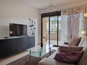- un salon avec un canapé et une télévision dans l'établissement City Center Apartment by NRAS, à Albir
