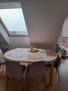 uma mesa com cadeiras num quarto com uma janela em Jasne słoneczne mieszkanie niedaleko lotniska em Gdansk
