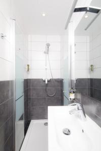 a bathroom with a shower and a white sink at Saint Aubin Logis Hôtel & Restaurant in Saint-Aubin-sur-Mer