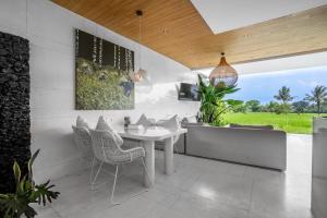a dining room with a white table and chairs at GREEN FlOW Villas Ubud II in Ubud