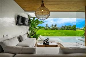 a living room with a couch and a large window at GREEN FlOW Villas Ubud II in Ubud