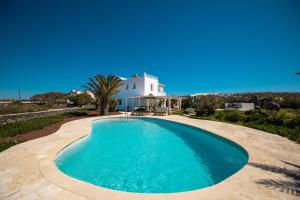 a swimming pool in front of a house at Oia Sunset Luxury Villa in Oia