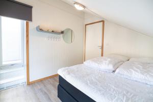 a bedroom with a white bed with a large window at Gjermesøy Luxury Apartment in Ballstad