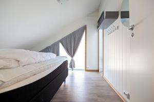 a bedroom with a large bed and a window at Gjermesøy Luxury Apartment in Ballstad +24 photos