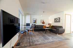 a living room with a couch and a tv at Gjermesøy Luxury Apartment in Ballstad