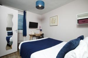 a hotel room with a bed and a television at Saint Aubin Logis Hôtel & Restaurant in Saint-Aubin-sur-Mer