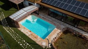 an overhead view of a swimming pool next to a house with solar panels at Casas Rurales Laguna La Tinaja in Ossa de Montiel