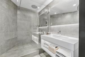 uma casa de banho branca com um lavatório e um espelho em Dancing House - Tančící dům hotel em Praga