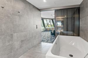 bagno con vasca e grande specchio di Dancing House - Tančící dům hotel a Praga