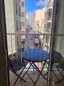 een tafel en stoelen op een balkon met uitzicht op een straat bij Shore View II Las Canteras by Canary365 in Las Palmas de Gran Canaria