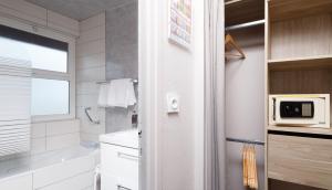 a white bathroom with a sink and a microwave at Saint Aubin Logis Hôtel & Restaurant in Saint-Aubin-sur-Mer