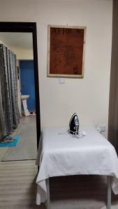 Cette chambre comprend une table blanche avec un miroir et un miroir. dans l'établissement Lacasa accommodation, à Naivasha